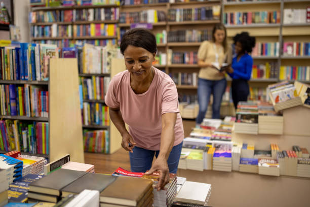 istock Woman choosing a book to buy 2159370938
