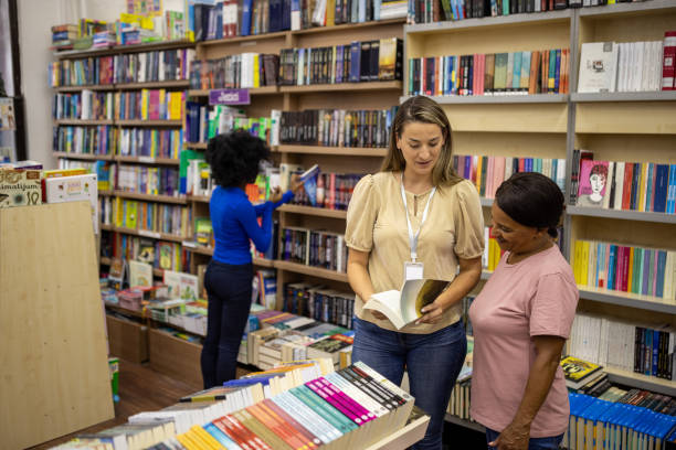 istock Saleswoman recommending a book to a customer 2159371217