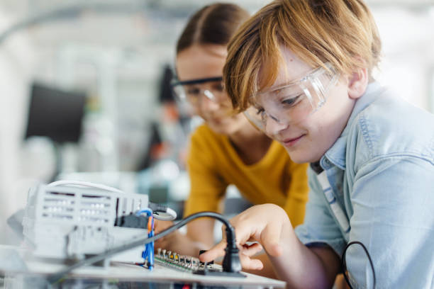 istock Two classmates working together on circuit board, building robot in after-school robotics club. Children learning robotics in Elementary school. 2159371703