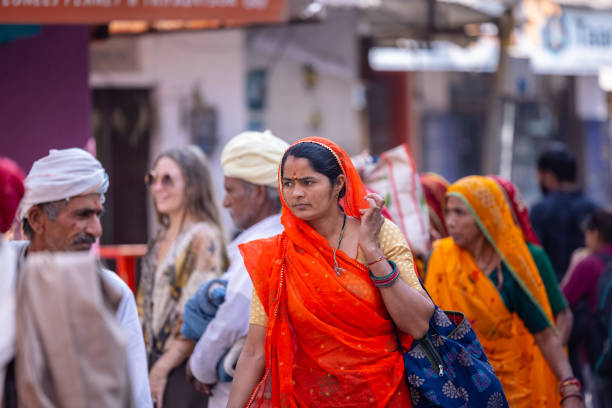 Pushkar, Rajasthan, India - November 2023: Pushkar fair, Portrait of woman from rajasthan in colorful traditional dress and veil on head at pushkar fair ground.