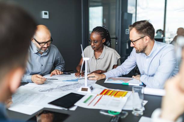 istock Colleagues discussing construction drawings on sustainable energy resources: windmills 2159374982