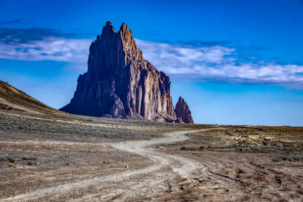 Ship Rock, New Mexico on a pleasant spring morning, dirt road through the desert leading to the famous landmark.
