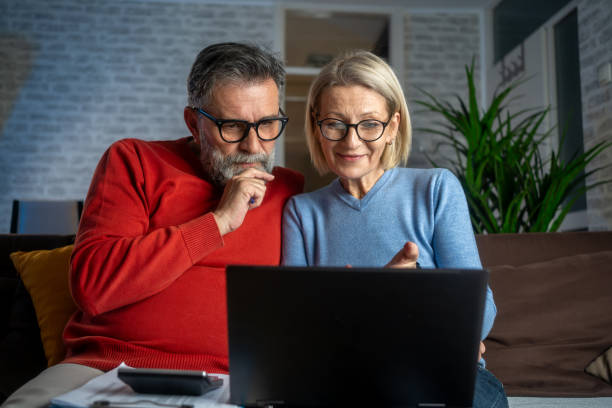 istock Couple at home making a reservation online using their laptop 2159377139