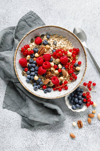 istock Muesli with organic berries and nuts. Oat muesli with raspberry, blueberry, red currant, almond, pecan, walnut, cashew, hazelnut and pumpkin seeds. Healthy food, top view 2159390974