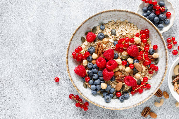 istock Muesli with organic berries and nuts. Oat muesli with raspberry, blueberry, red currant, almond, pecan, walnut, cashew, hazelnut and pumpkin seeds. Healthy food, top view 2159391048