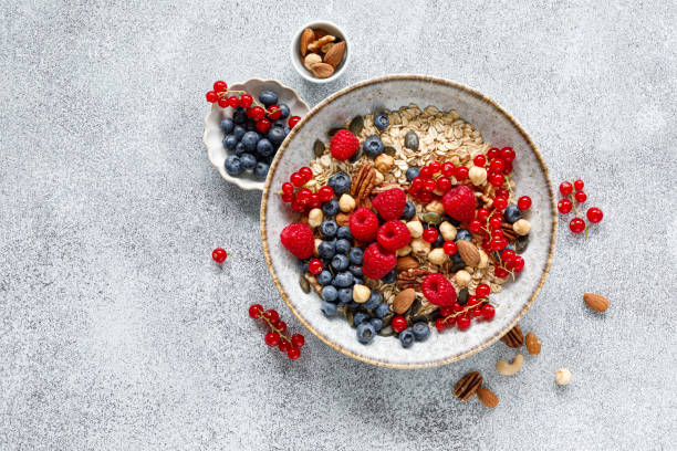 istock Muesli with organic berries and nuts. Oat muesli with raspberry, blueberry, red currant, almond, pecan, walnut, cashew, hazelnut and pumpkin seeds. Healthy food, top view 2159391049