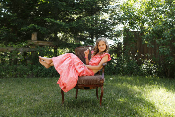 Happy little girl day dreaming while relaxing on chair at balcony.