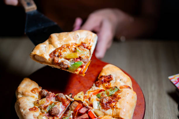 istock Freshly baked pizza on a wooden paddle 2159398386
