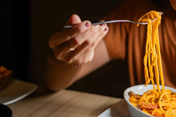istock Person eating spaghetti with creamy orange sauce 2159398720