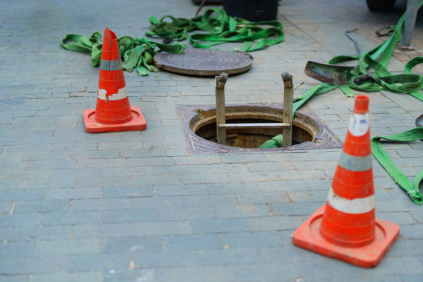 istock sewer manhole with a ladder lowered into it, enclosed by special cones on the sidewalk, ensuring safety and access to underground infrastructure in urban areas 2159400002