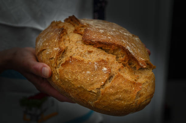 istock Woman with fresh baked sourdough bread in kitchen 2159401111