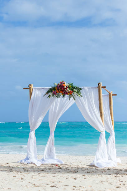 An empty wedding gazebo with white curtains and flowers decoration