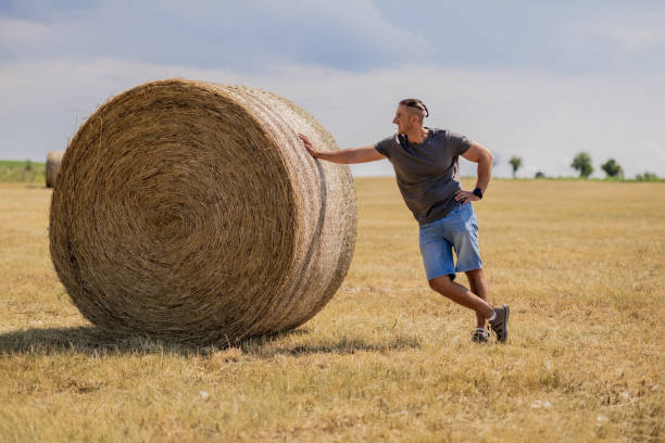 istock A man leaning on hay Bale in agriculture field 2159408714