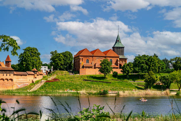 istock Ancient medieval village church reflected in the river water 2159410747