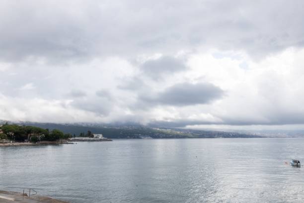 istock coastal landscape with a cloudy sky and calm waters, featuring a distant shoreline and a small boat 2159410844