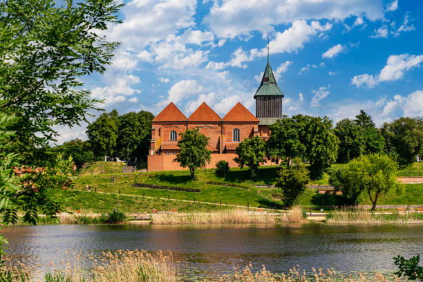 istock Ancient medieval village church reflected in the river water 2159412689