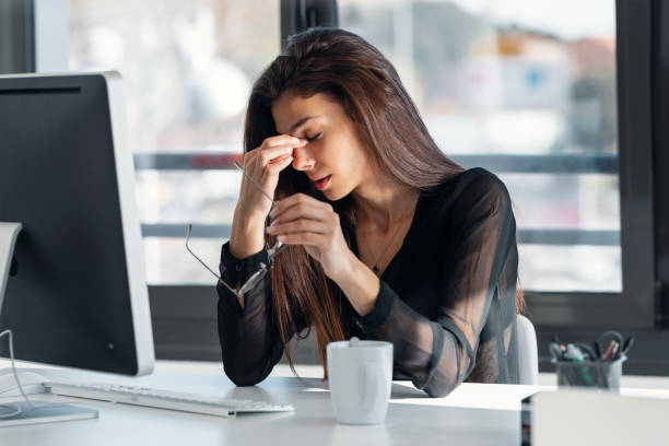 istock Exhausted elegant business woman with headache while working with computer in the office. 2159414374