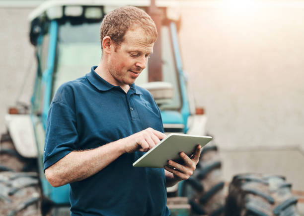 istock Farmer, internet and man with tablet by tractor for production, schedule and research on industry. Farming, website and male person with tech for agriculture, information and reading weather update 2159419129