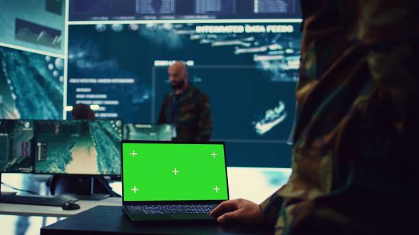 istock Army officer studies isolated greenscreen display on a laptop in control room 2159420329