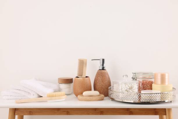 istock Different bath accessories and personal care products on table near white wall 2159425601