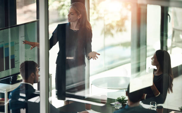 istock Office, pointing and businesswoman with presentation on computer screen, data analysis and graphs. Finance team, female analyst and meeting for discussion, feedback or statistics review by glass wall 2159428309