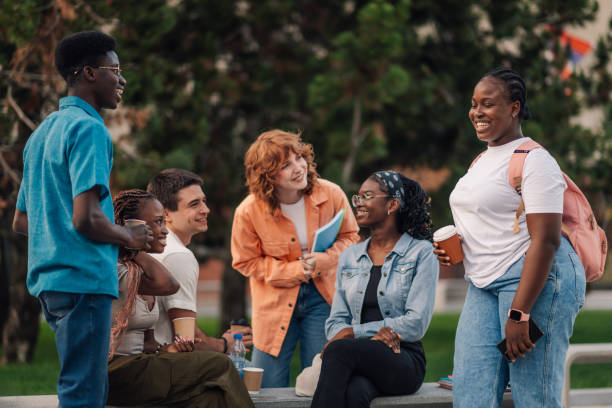 istock Happy diverse students standing at campus and chatting on coffee break 2159431408