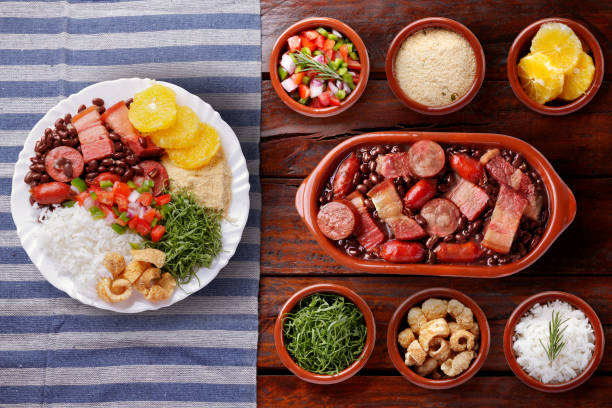 istock Brazilian feijoada, traditional food from Brazil cuisine, on ceramic casserole bowl, over rustic wooden table 2159432735