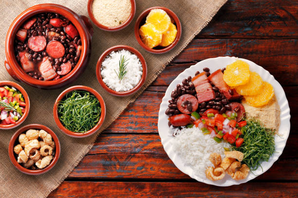 Brazilian feijoada, traditional food from Brazil cuisine, on ceramic casserole bowl, over rustic wooden table