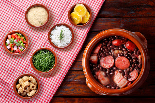istock Brazilian feijoada, traditional food from Brazil cuisine, on ceramic casserole bowl, over rustic wooden table 2159432738