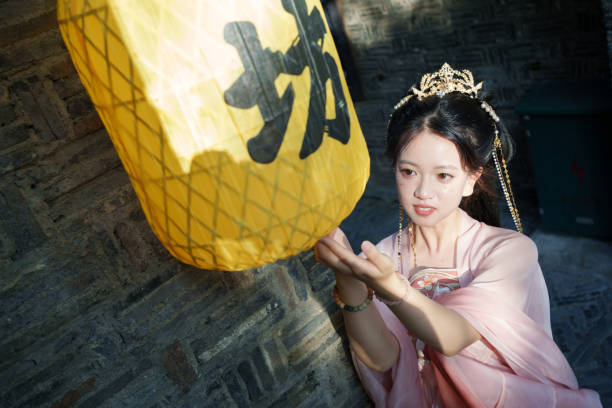 Woman in Hanfu touching lantern with hand