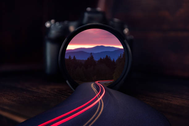 Scenic mountain view with winding road and traffic trails spilling out of camera lens. Taken along the Blue Ridge Mountains of North Carolina