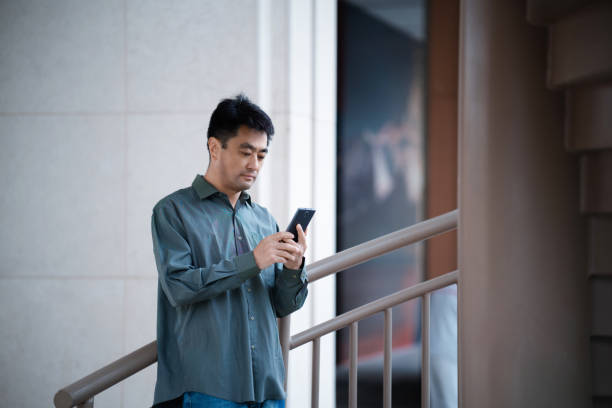 istock Middle-aged man using smartphone in city street 2159445748