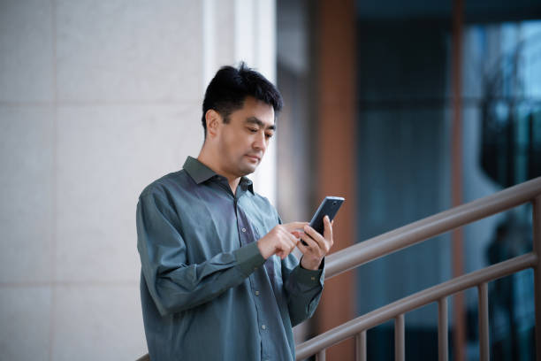 istock Middle-aged man using smartphone in city street 2159445750