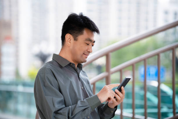 istock Middle-aged man using smartphone in city street 2159445777