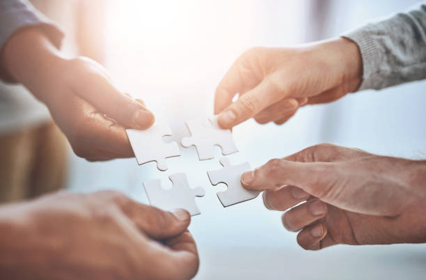 istock People, hands and puzzle together for partnership, problem solving and collaboration on company project. Group, diversity and community for solidarity or unity with teamwork, synergy and work support 2159447191