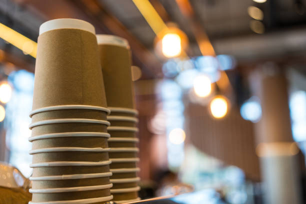 Stack of brown kraft cups stacked upside down on a shelf at the coffee shop