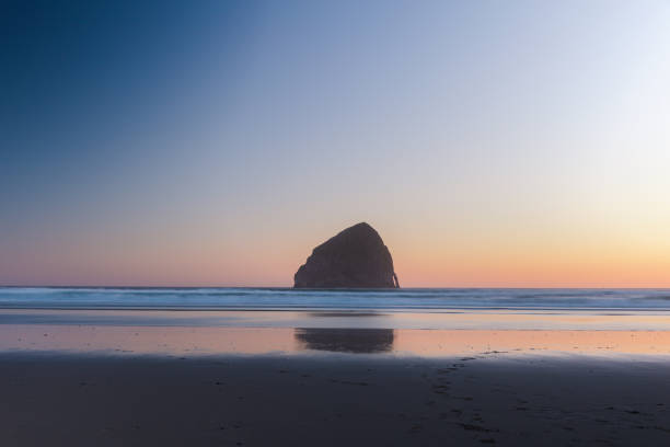 A peaceful and calming scene as the sun sets over the Pacific Ocean on the Oregon Coast in summer time. Vacation, road trip and landscape concepts.