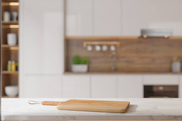 istock Cutting Board On Empty White Marble Countertop With Blurred Kitchen Background 2159458966