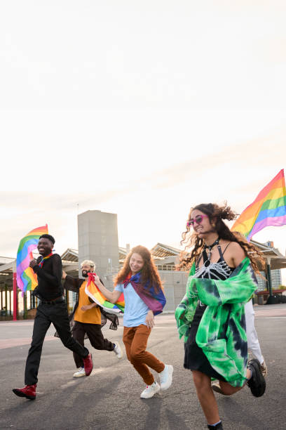 istock A happy group dances down the street holding rainbow flags 2159459989