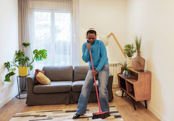 istock Woman singing with broom as microphone 2159460044