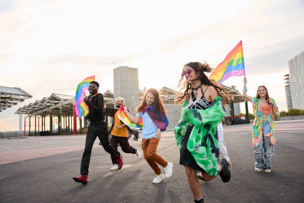 istock A happy group dances down the street holding rainbow flags 2159460063