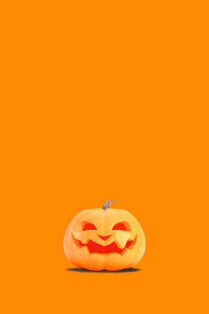 Jack o lantern isolated on orange vertical background for halloween concept. Smiling orange pumpkin backdrop idea, social media template design.