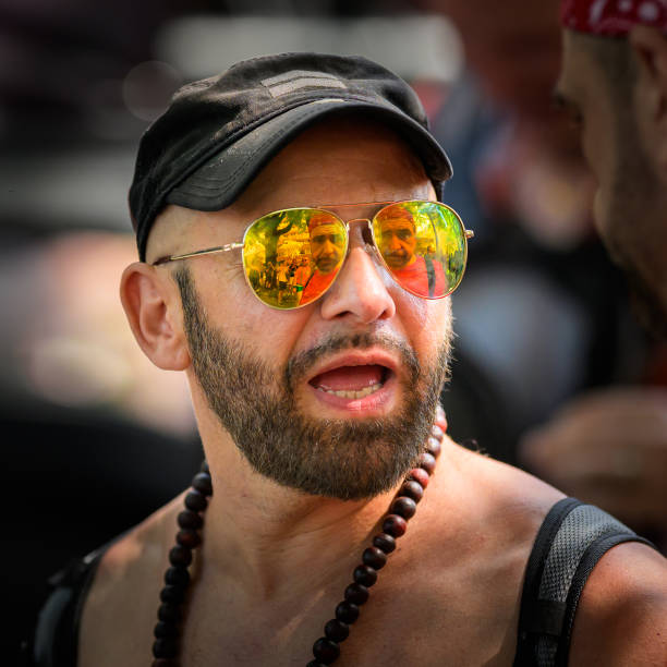Vienna, Austria - June 08, 2024: People at Vienna Pride in summer on Wiener Ringstrasse, portrait of a man with colorful, reflective sunglasses