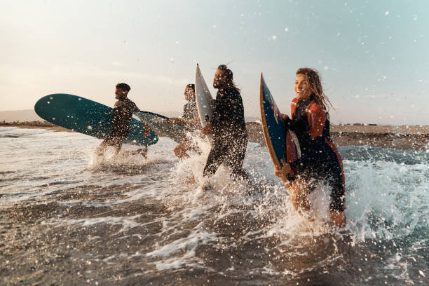 istock Carefree surfers having fun while surfing in sea. 2159462448