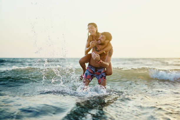 istock Cheerful couple having fun while piggybacking at sea. 2159462510