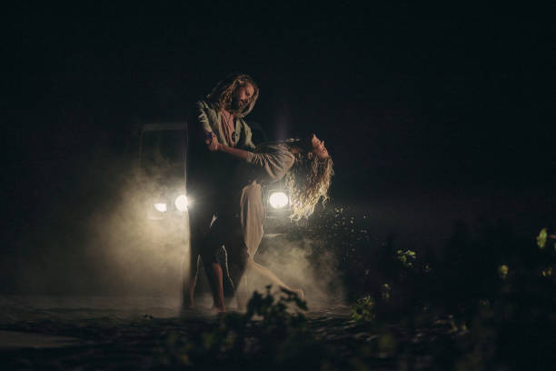 istock Romantic couple dancing in front of parked car by night. 2159462687
