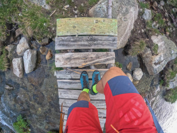 istock Male hiker crossing mountain river 2159463002