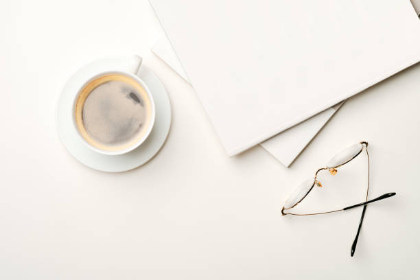 istock Blank paper, coffee cup and glasses on white desk 2159463026