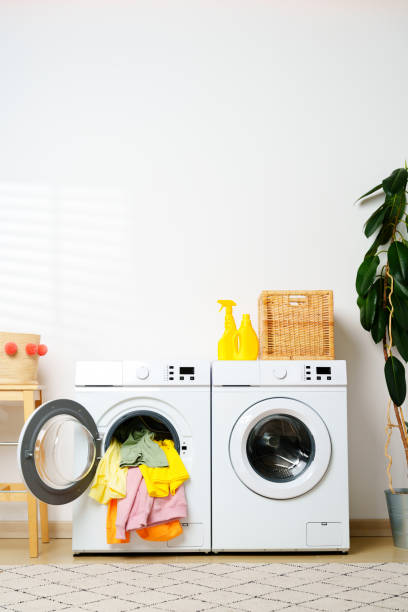 istock Modern Laundry Room With White Washing Machines and Colorful Clothes 2159463725