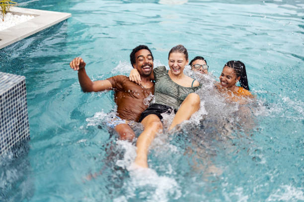 istock Playful friends having fun in the swimming pool. 2159463973